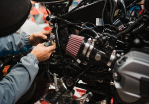 Mechaniker repariert Motorrad in der Werkstatt