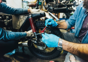 Zwei Mechaniker warten ein Motorradfahrwerk